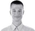 Headshot of Marcin Doliński smiling, wearing a collared shirt. Black and white image with split background.