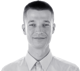 Headshot of Marcin Doliński smiling, wearing a collared shirt. Black and white image with split background.