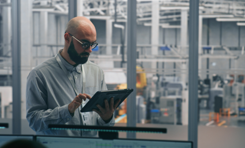 Manager using tablet in factory control room
